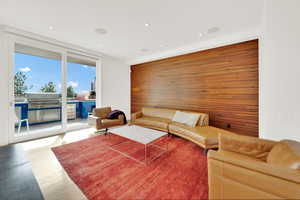 Living room with wood finished floors, wood walls, and recessed lighting