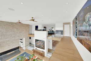 Living area with a glass covered fireplace and light wood finished floors