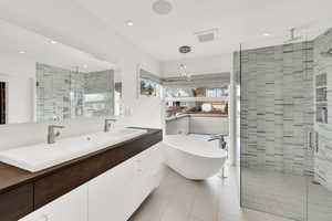 Full bath with a shower stall, double vanity, a soaking tub, recessed lighting, and light tile patterned flooring