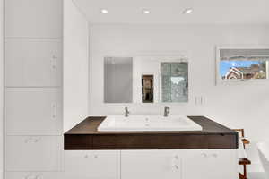 Bathroom featuring double vanity, a shower stall, a walk in closet, and a freestanding tub