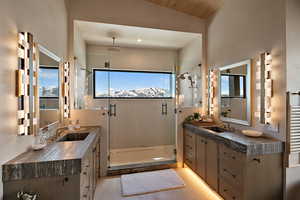 Full bathroom with two vanities, a stall shower, and recessed lighting