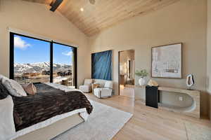 Bedroom featuring light wood finished floors, ensuite bathroom, a high wood beamed ceiling, a mountain view, and recessed lighting