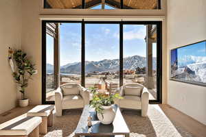 Living room with wood finished floors, a mountain view, and lofted ceiling