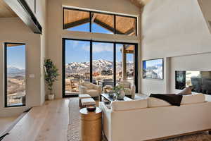 Living area with a mountain view, hardwood / wood-style floors, and a vaulted wooden ceiling