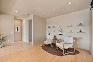 Living area with light wood-style floors and recessed lighting