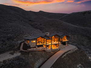 Rear view of house featuring a patio area and stone siding