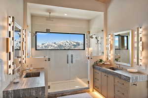 Full bathroom with two vanities, a shower stall, and recessed lighting
