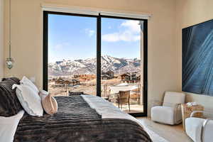 Bedroom with wood finished floors, a residential view, a mountain view, and access to outside