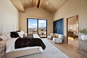 Bedroom featuring a mountain view, access to outside, a high wood beamed ceiling, hardwood / wood-style floors, and ensuite bath
