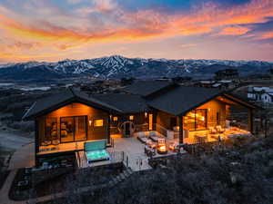 Rear view of property with an outdoor lounge area, a mountain view, roof with shingles, and a patio
