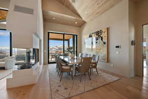 Dining space with a vaulted wood ceiling, light wood finished floors, a mountain view, and recessed lighting