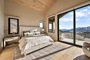 Bedroom featuring a vaulted wooden ceiling, recessed lighting, light wood-type flooring, a mountain view, and access to exterior