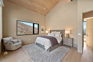 Bedroom with a vaulted wooden ceiling, light wood finished floors, recessed lighting, and a mountain view
