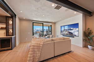 Living area with wine cooler, light wood-type flooring, and recessed lighting