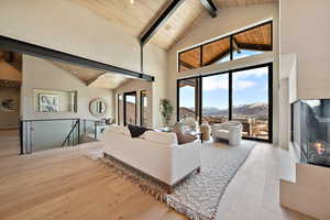Living room featuring a mountain view, light wood finished floors, and a high wood beamed ceiling