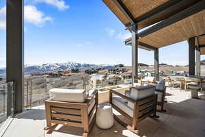 View of patio / terrace featuring a mountain view, an outdoor living / dining area, and a residential view