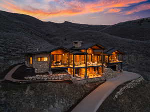 Rear view of property featuring stone siding, a chimney, and a mountain view