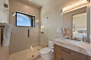 Full bath featuring vanity, a marble finish shower, and connected bathroom