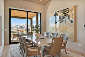 Dining space featuring a mountain view, light wood-style flooring, and wooden ceiling