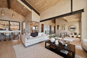 Living room featuring a high wood beamed ceiling, light wood-type flooring, and recessed lighting