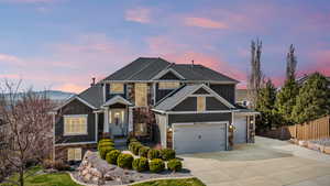 Craftsman house with board and batten siding, concrete driveway, an attached garage, and stone siding