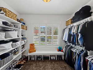 Walk in closet featuring dark carpet
