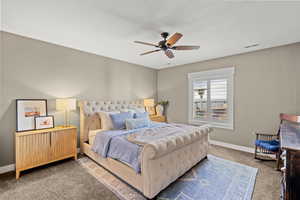 Bedroom with dark carpet and ceiling fan