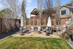 Fenced backyard featuring an outdoor fire pit and a patio