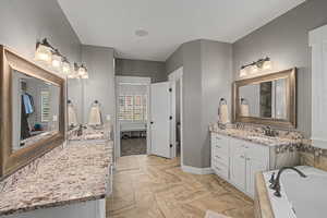 Bathroom featuring two vanities and a garden tub