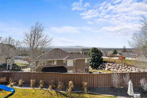 Back of property featuring stucco siding, a fenced backyard, and a residential view