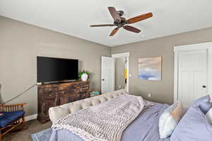 Bedroom with a ceiling fan and carpet