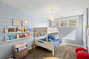 Bedroom featuring wood walls and carpet flooring