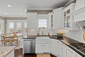 Kitchen featuring white cabinets, stainless steel appliances, dark wood-style flooring, recessed lighting, and glass insert cabinets