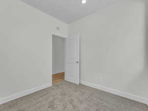 Empty room with baseboards and light carpet