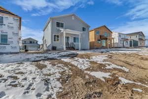 Snow covered rear of property with a residential view