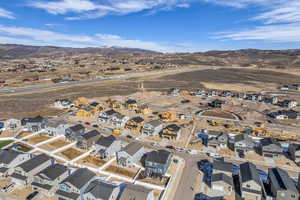 Aerial view of property and surrounding area featuring nearby suburban area and a mountainous background