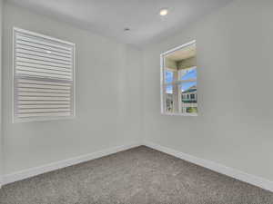 Empty room featuring baseboards and carpet