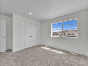 Unfurnished bedroom with carpet, a closet, and a textured ceiling