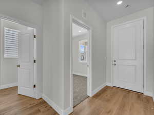 Foyer entrance with light wood-style floors and recessed lighting