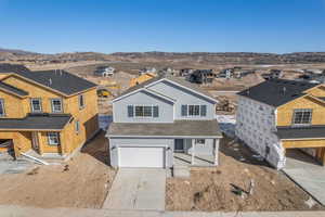 View of front facade featuring an attached garage, driveway, and a residential view