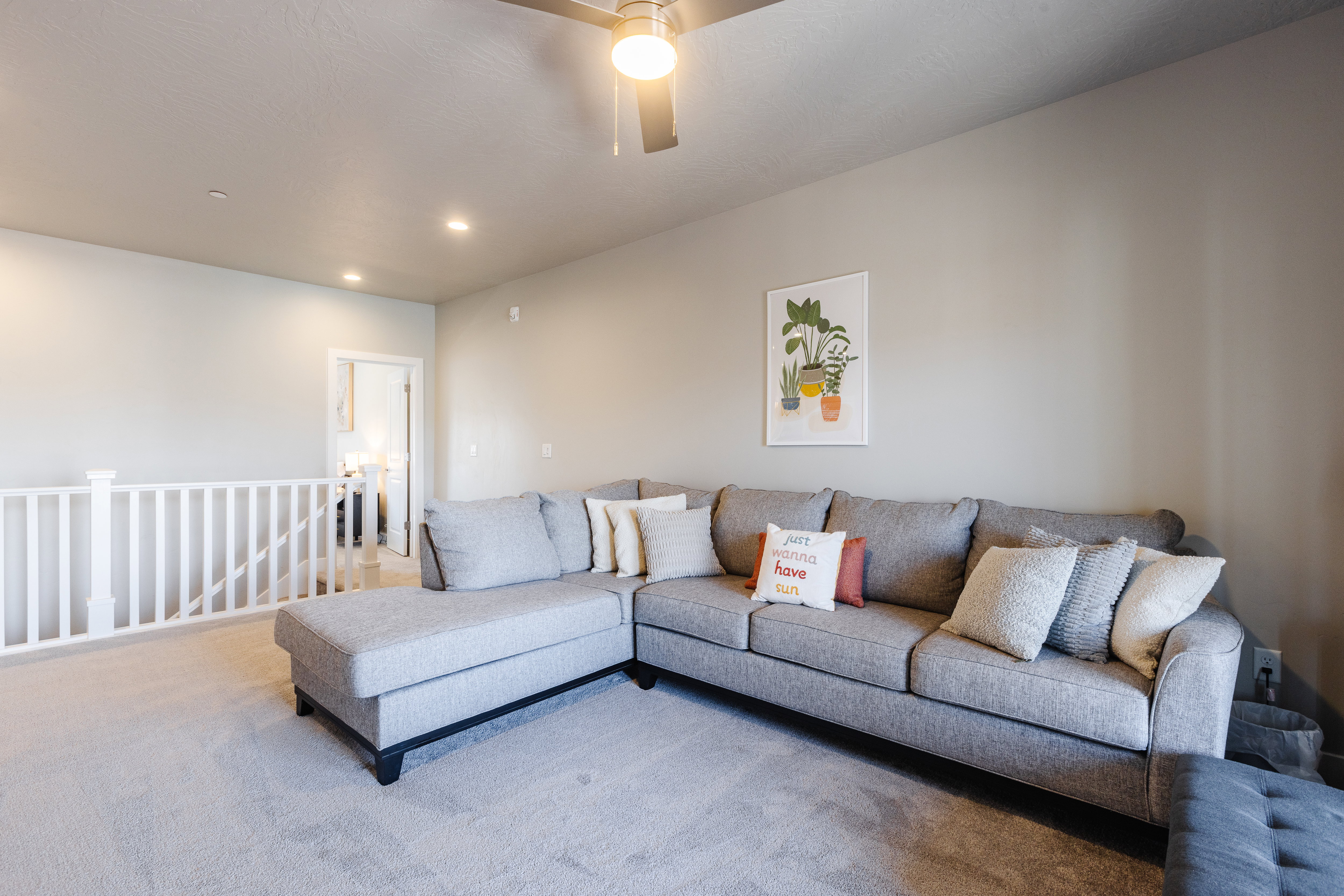 Carpeted living room featuring ceiling fan and recessed lighting