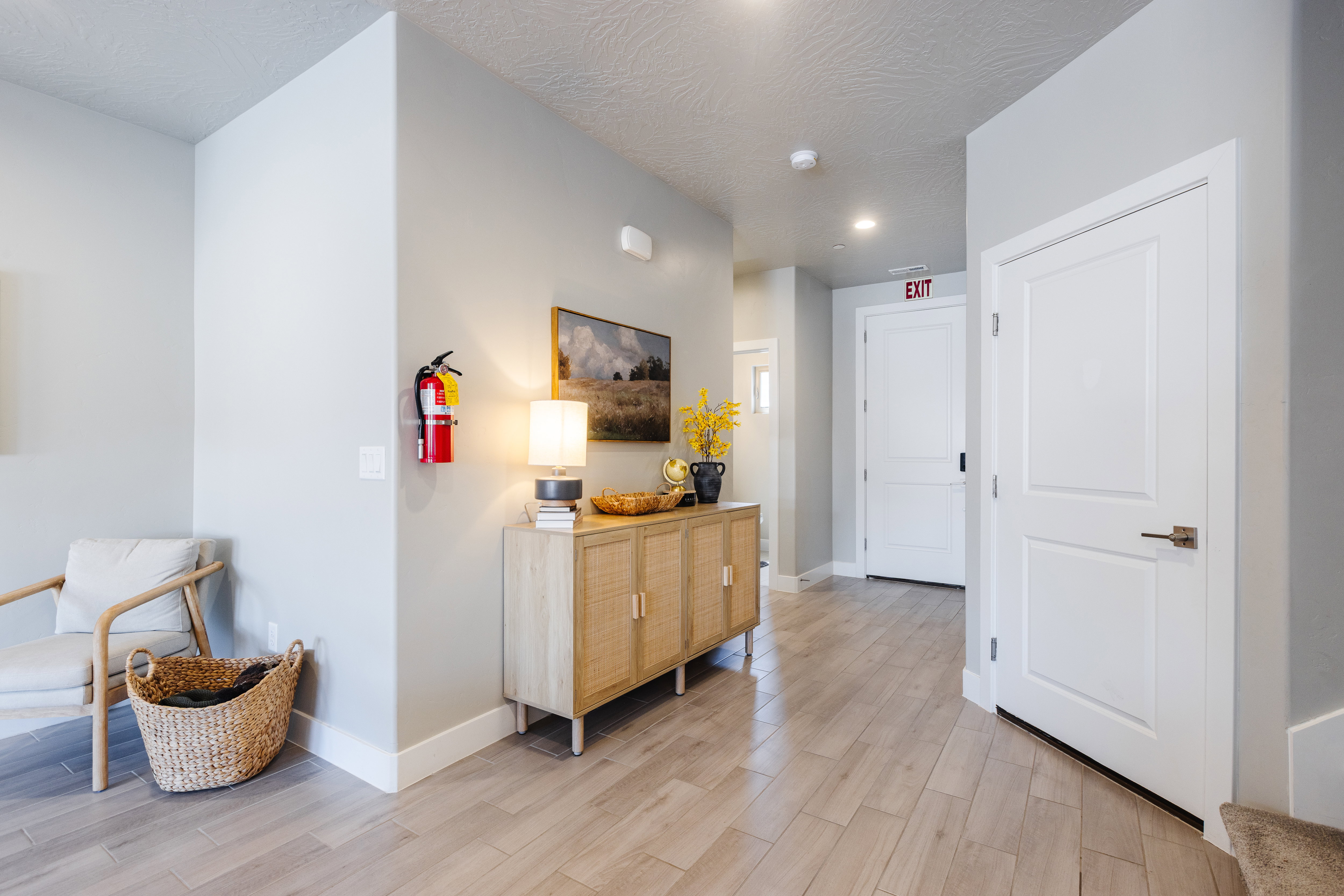 Hall with light wood-style flooring and a textured ceiling
