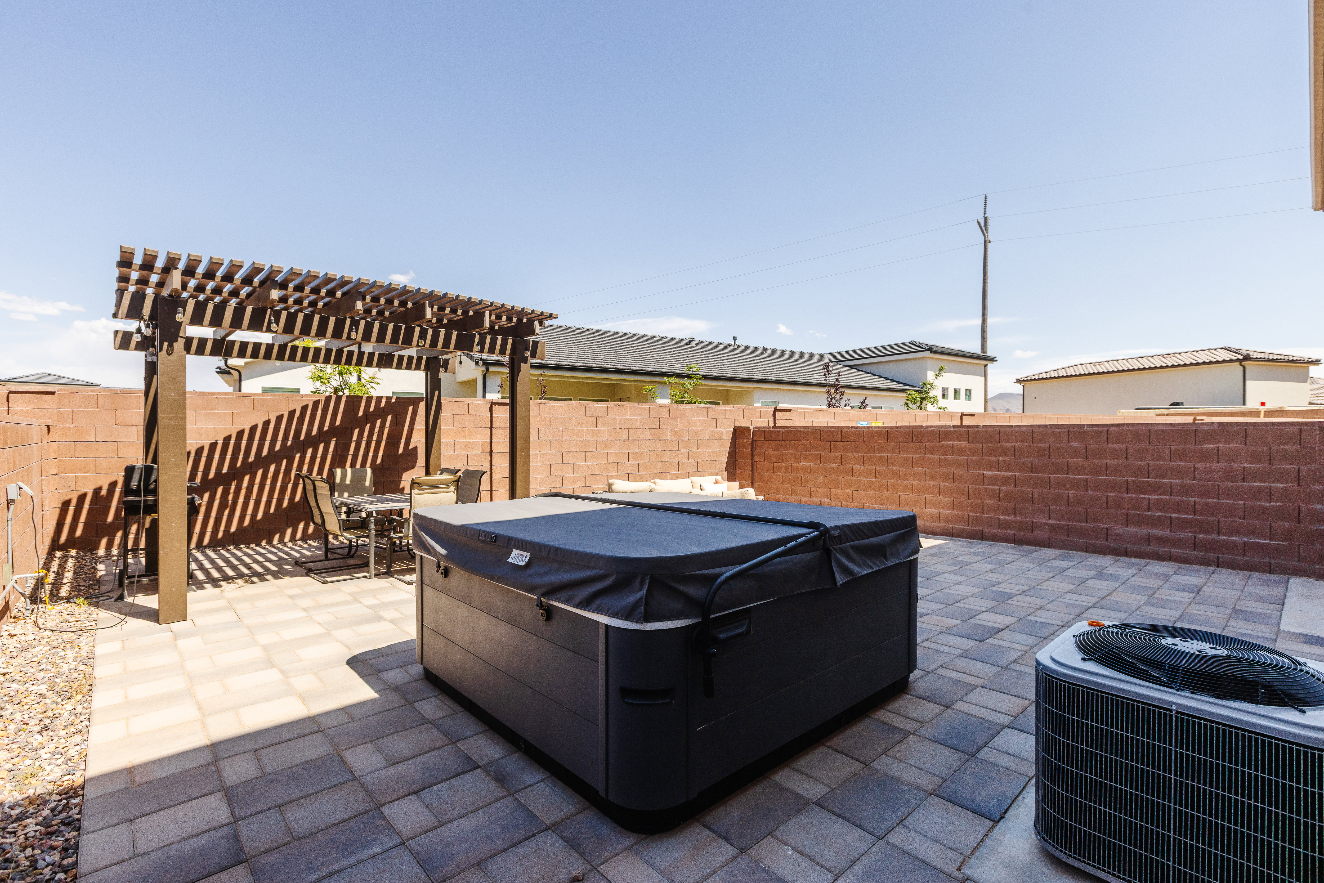 Fenced backyard featuring a patio, a pergola, and a hot tub