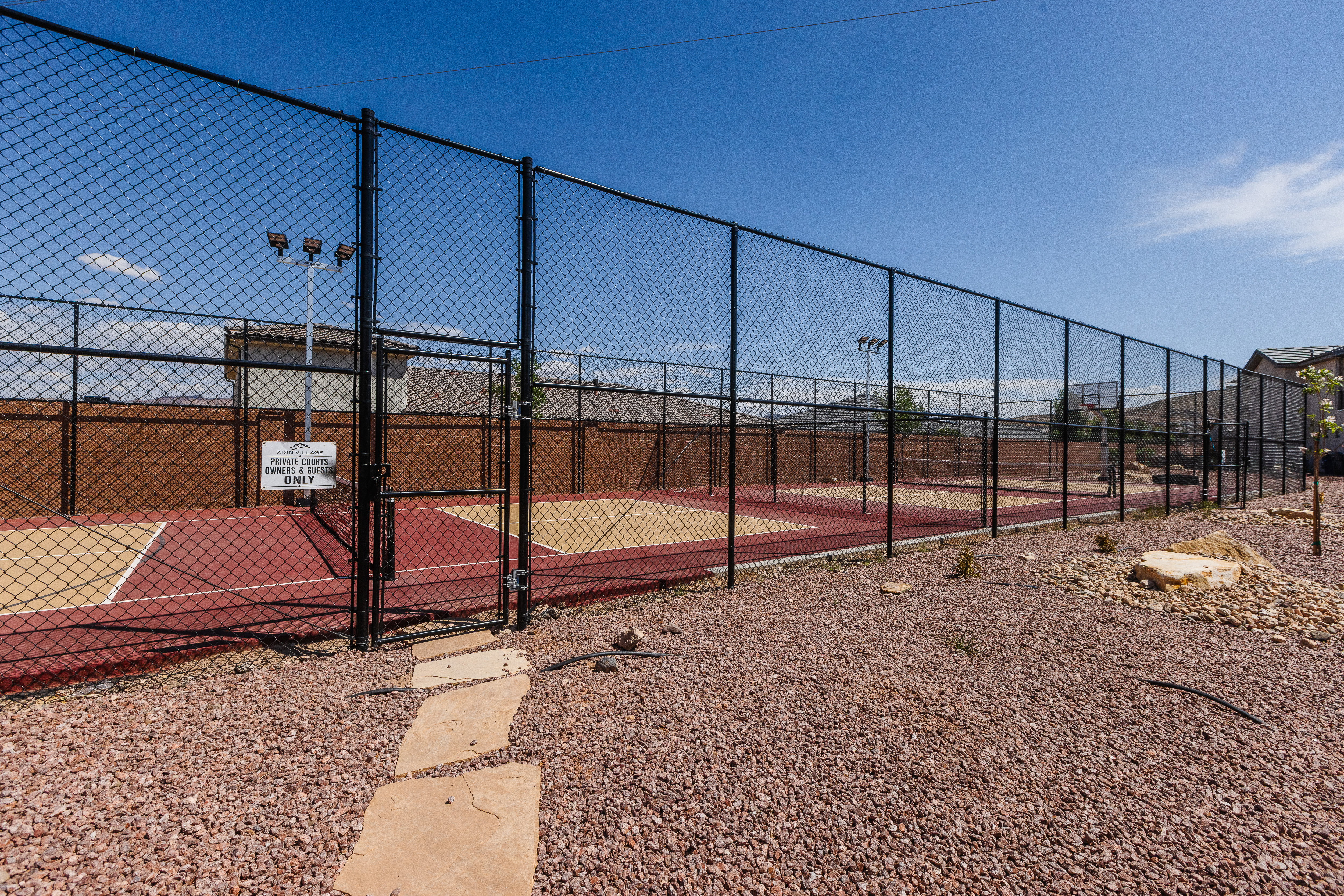View of tennis court with a gate
