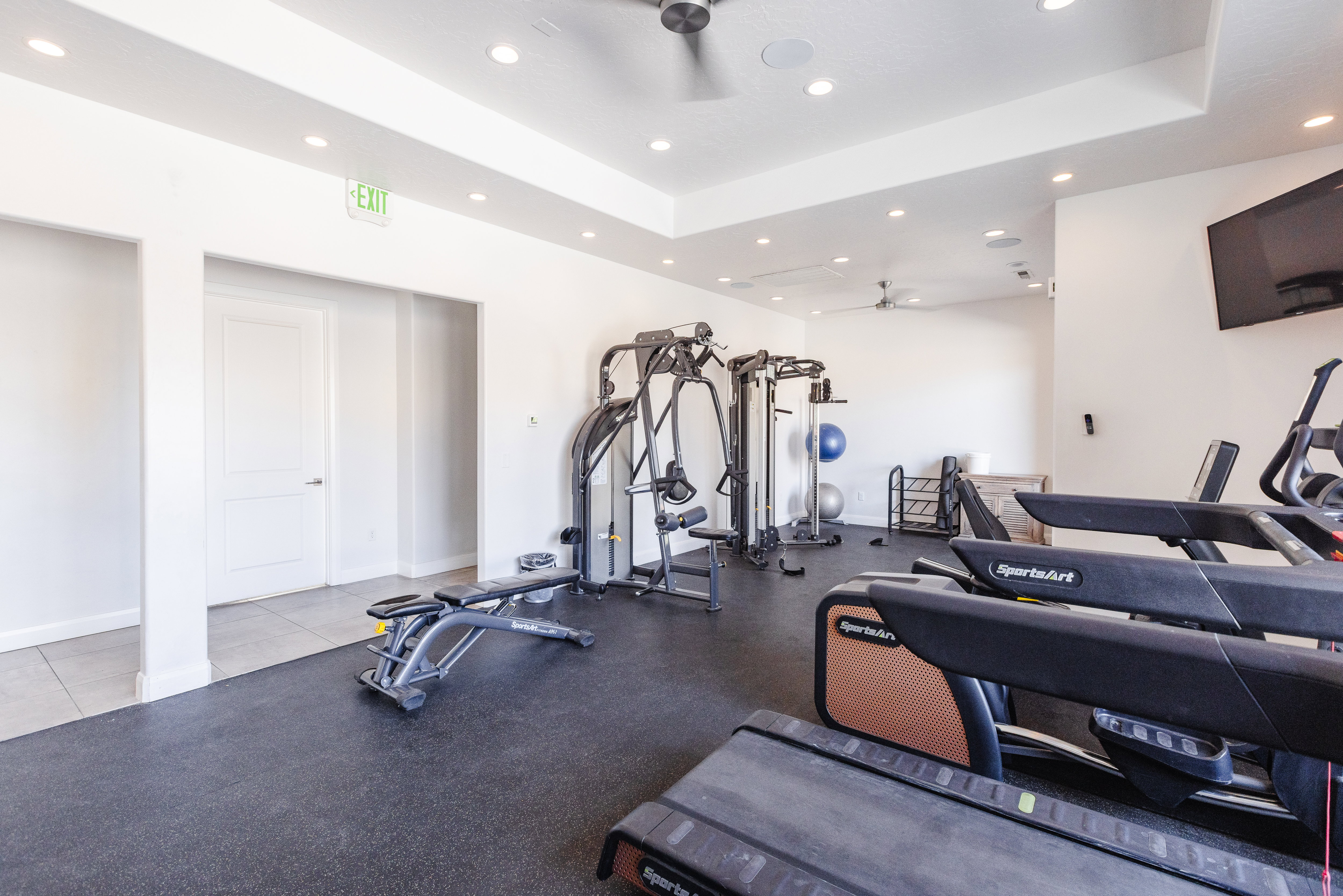 Exercise room featuring a raised ceiling, a ceiling fan, and recessed lighting