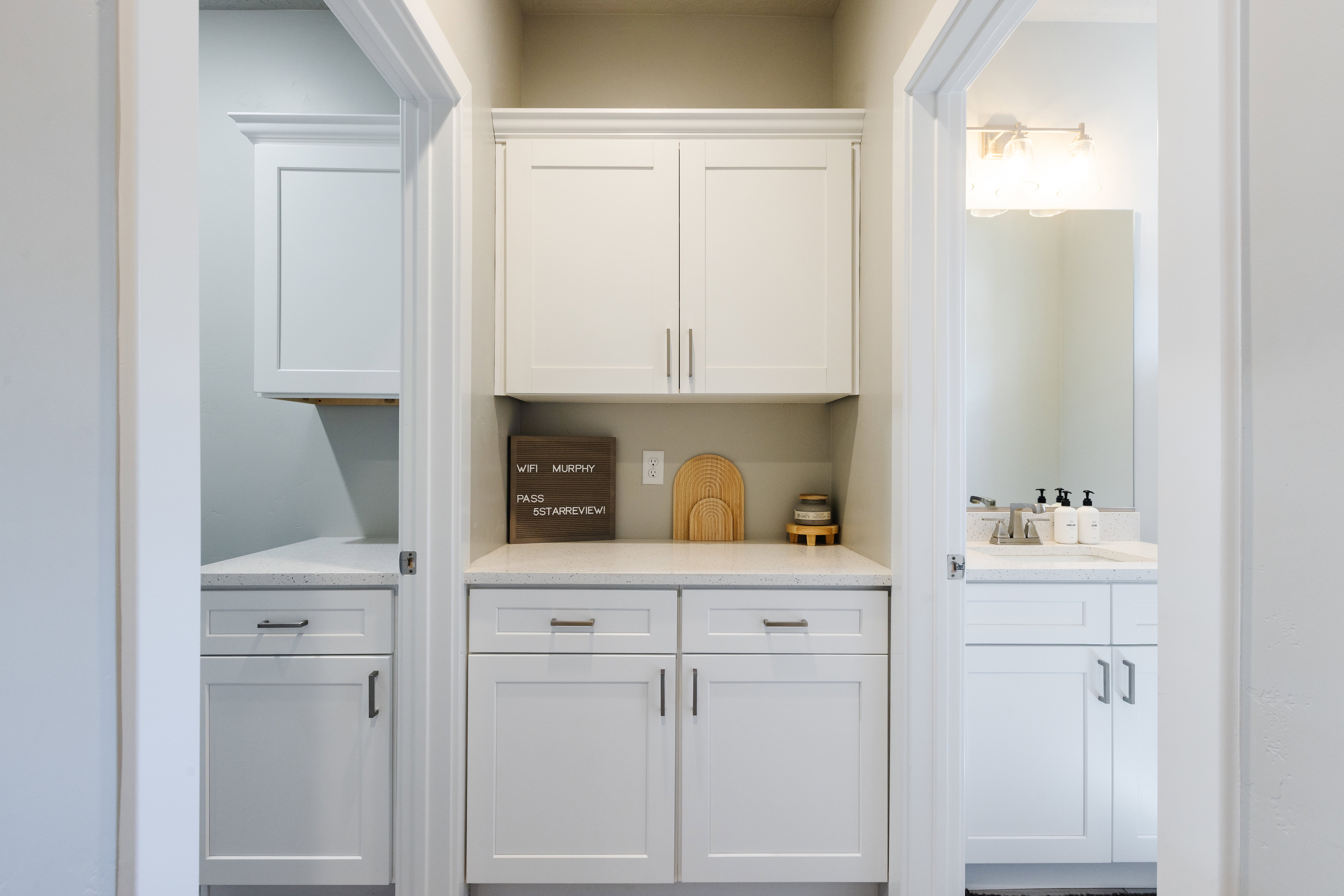 Bar with white cabinets and light stone countertops