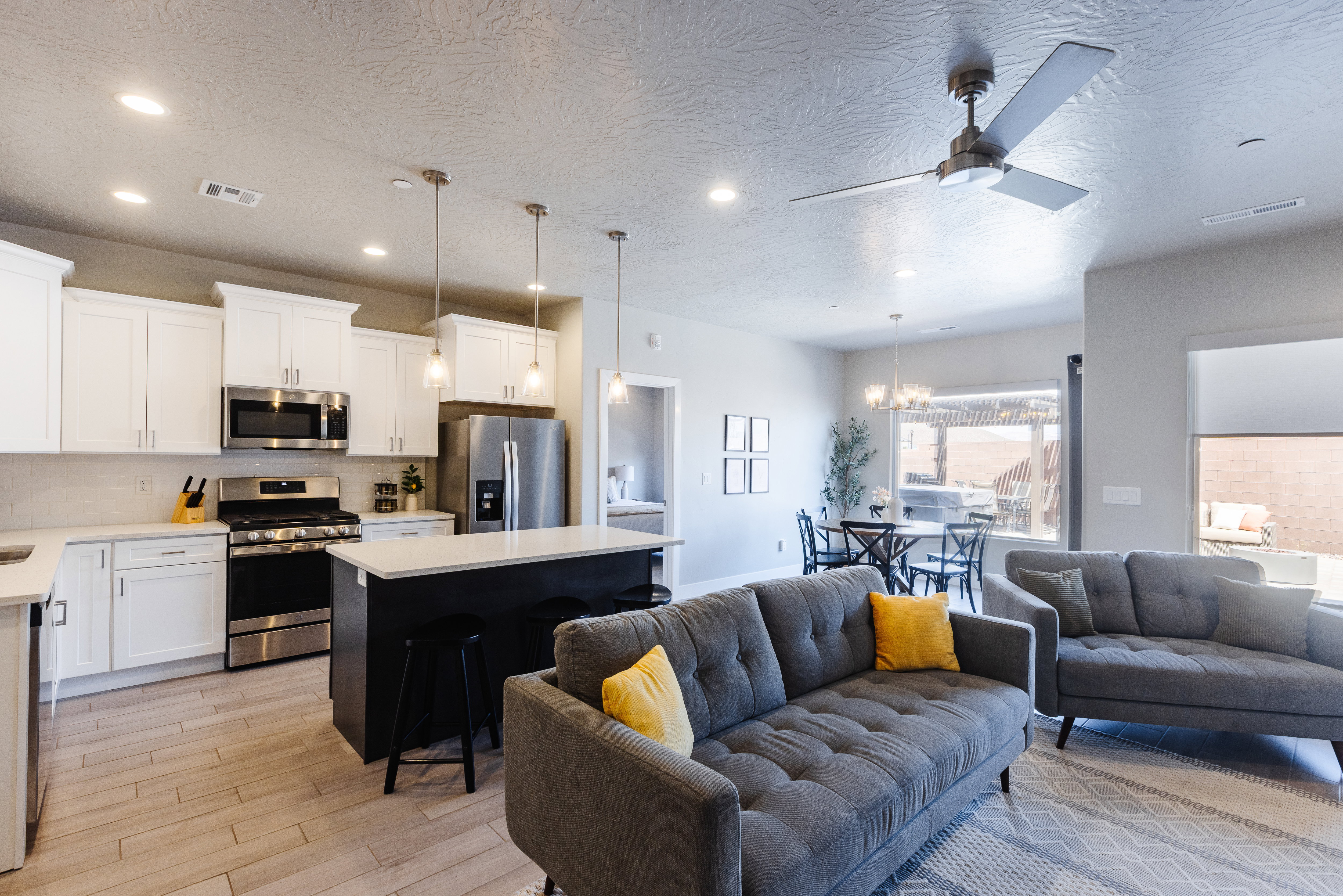 Kitchen featuring open floor plan, a center island, stainless steel appliances, white cabinets, and light wood-type flooring