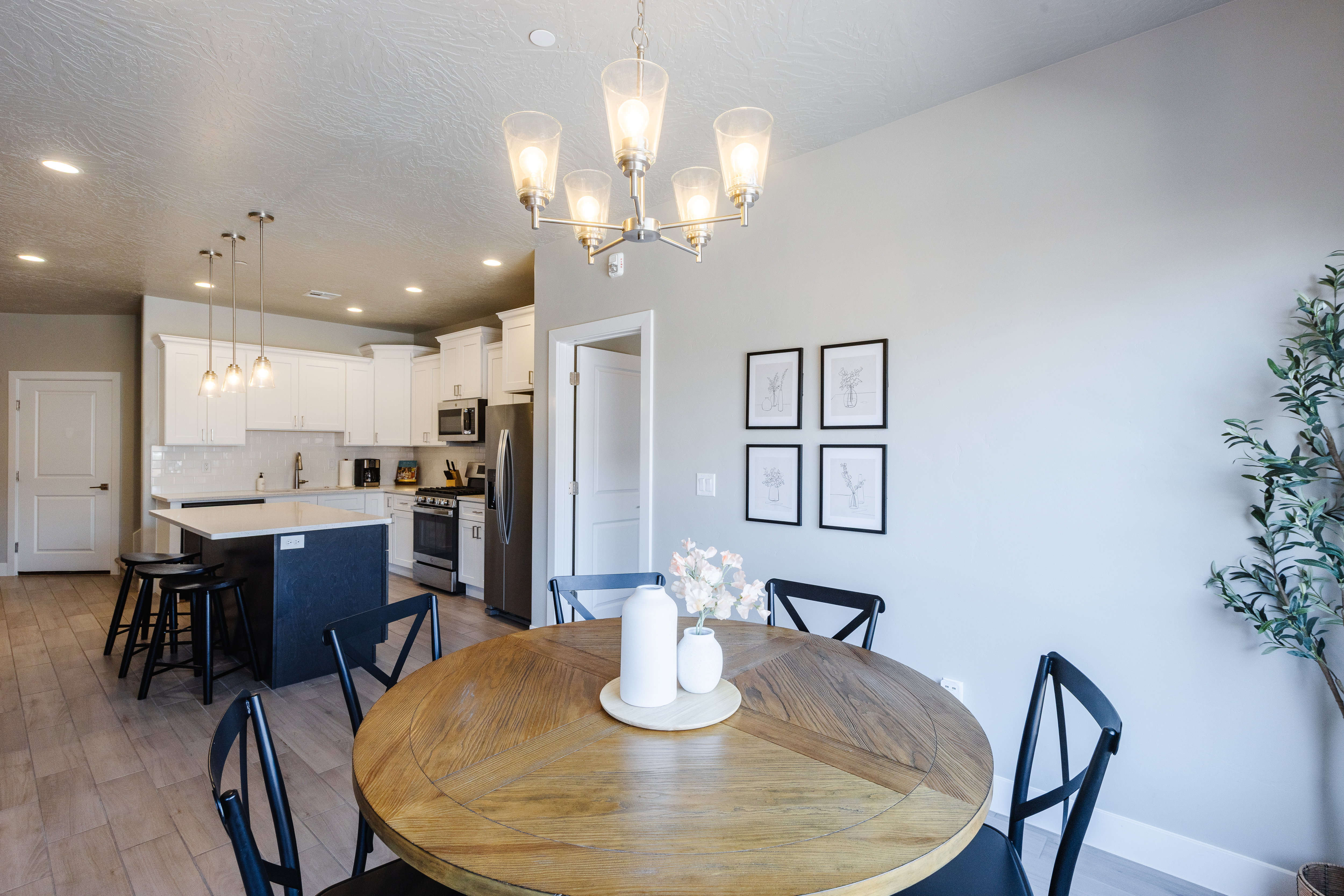 Dining area with hanging lights, light wood-style floors, and a textured ceiling
