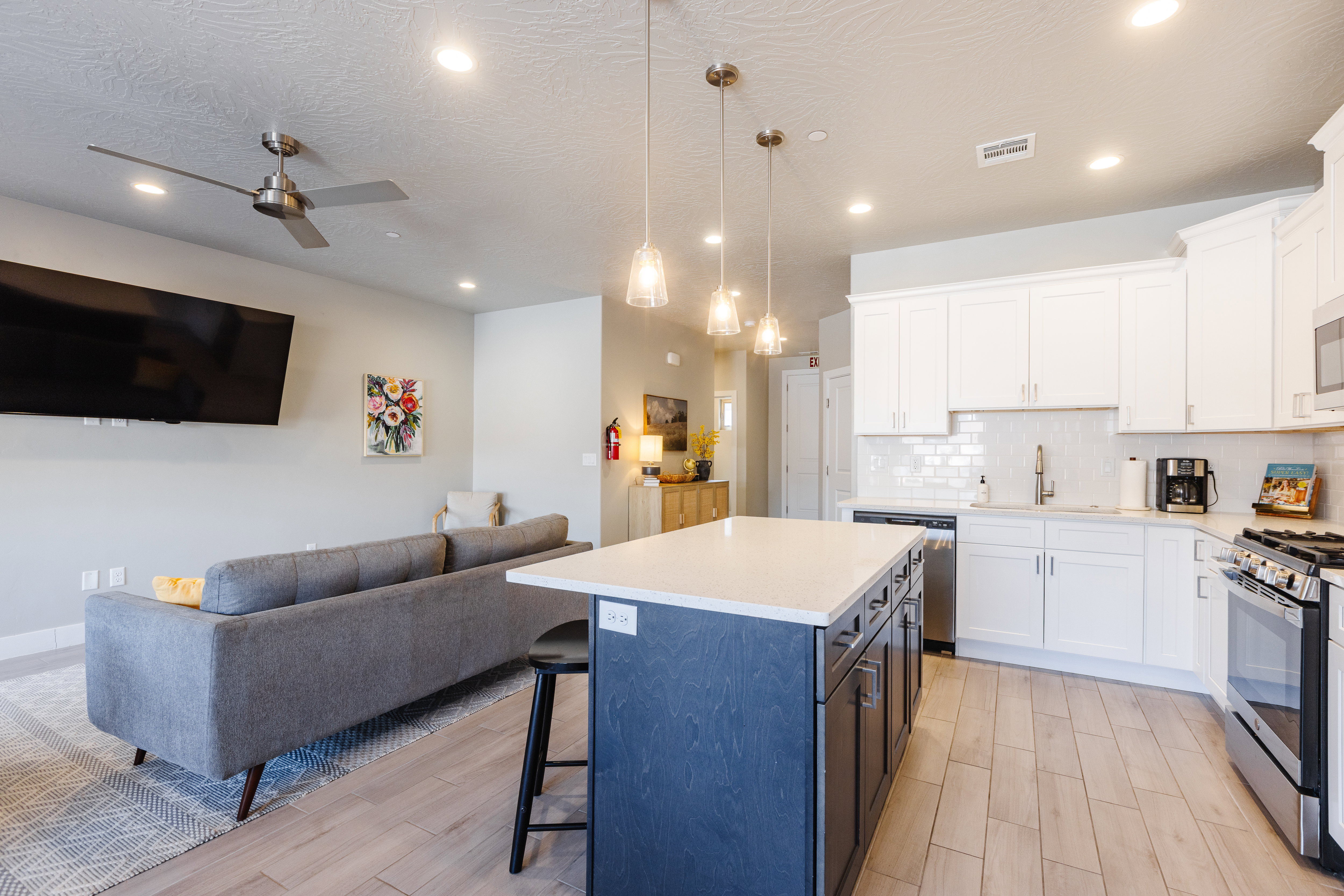 Kitchen with dual tone cabinets, open floor plan, a breakfast bar, a center island, and stainless steel appliances