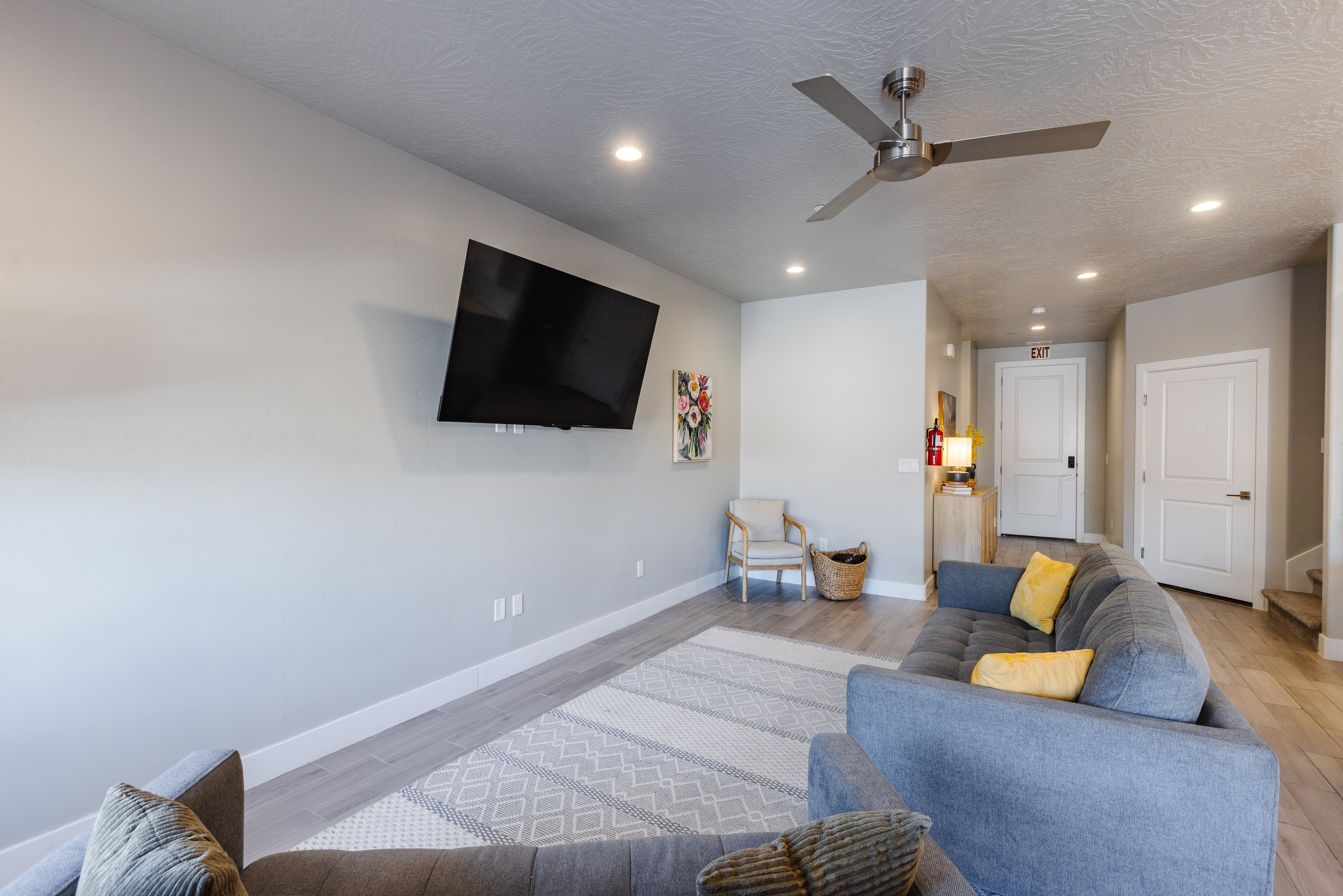 Living room featuring light wood-style floors, ceiling fan, recessed lighting, and a textured ceiling